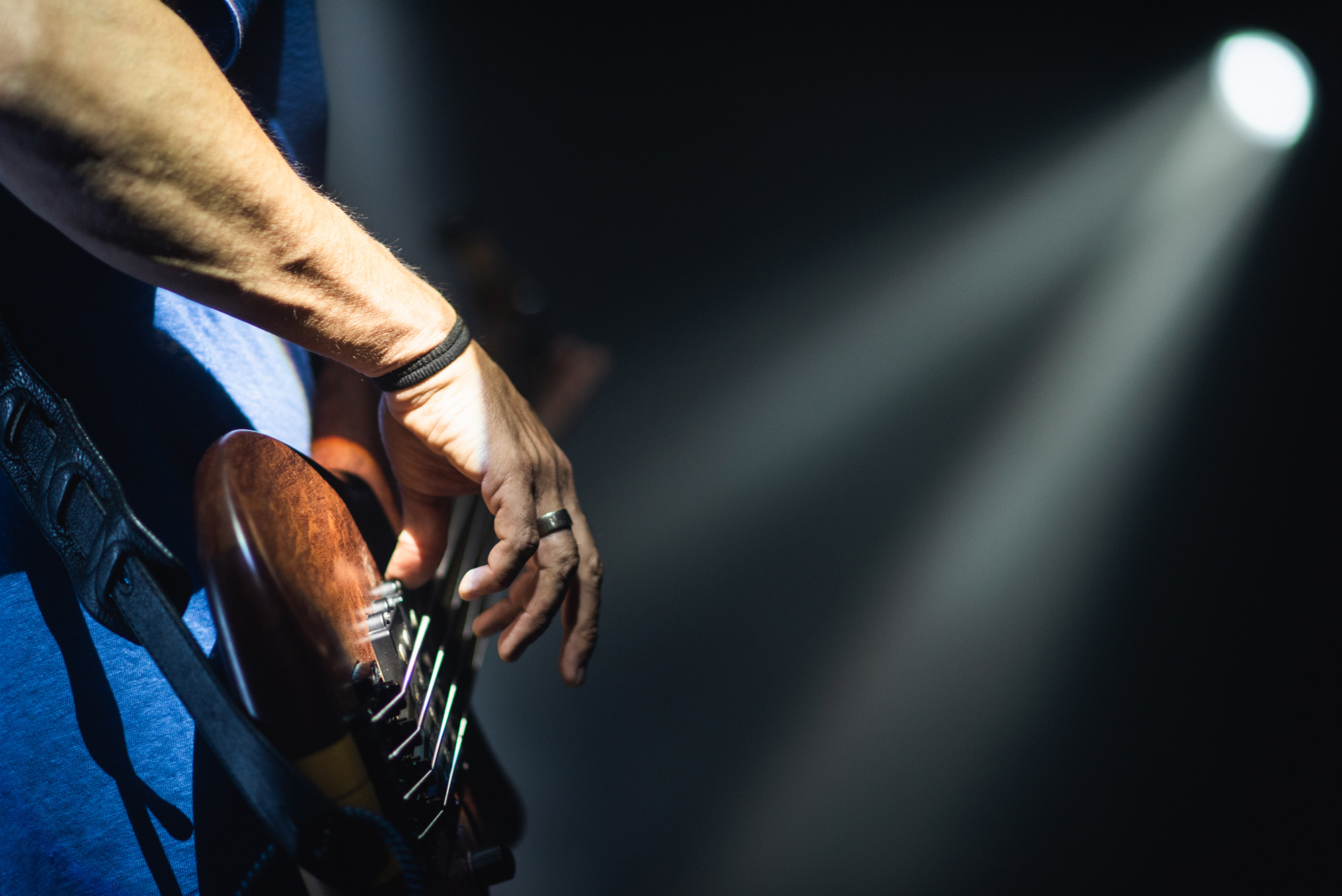 Mano de un guitarrista sobre las cuerdas con un foco de luz