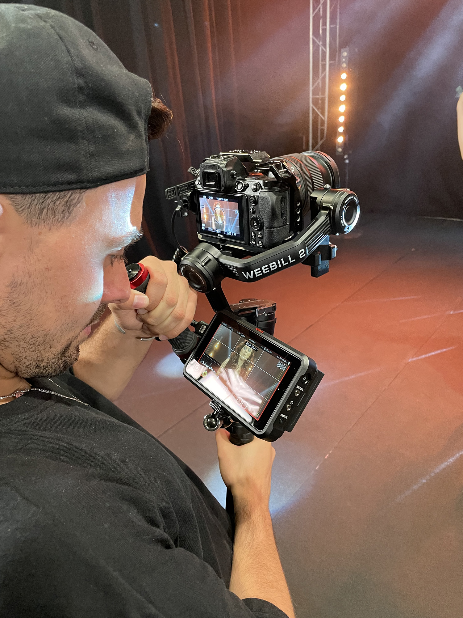 Videografo con cámara filmando a una artista